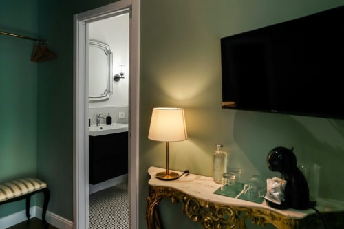 Camera Deluxe Casa Beretti a Catania con bagno privato, lampada da scrivania, TV e pareti verde menta