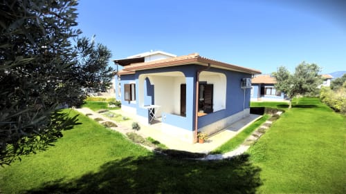 Villa bianca e blu con vista sul giardino presso A Mare Case Vacanze a Valledoria, con patio e spazi curati