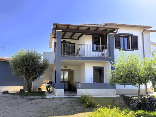 Moderno appartamento presso A Mare Case Vacanze a Valledoria con vista giardino, caratterizzato da facciata bianca, balcone privato e