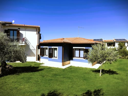 Elegante appartamento con accenti blu presso A Mare Case Vacanze a Valledoria, Italia, con terrazza, vista sul giardino e ulivi