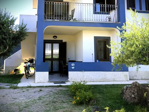 Moderna struttura bianca e blu con ingresso privato, vista sul giardino e bicicletta presso A Mare Case Vacanze a Valledoria