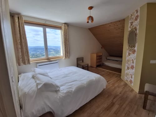 Chambre Passiflore at La Maison de Dun with mountain views, wooden beams, and white bedding
