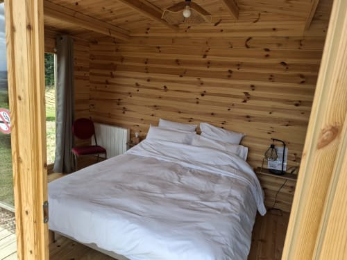 Chambre cosy en bois avec literie blanche à La Maison de Dun, gîte à Saint Racho, France