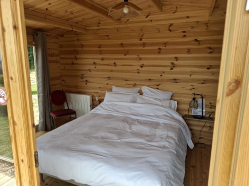Chambre douillette en bois de la suite Douglas à La Maison de Dun, avec lit aux draps blancs et vue sur les montagnes