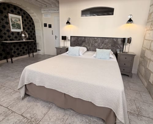 Zimmer C im Hôtel La Suite in Villeneuve-lès-Avignon mit Queensize-Bett, weißer Bettwäsche, dunklem Kopfteil, Nachttischen,