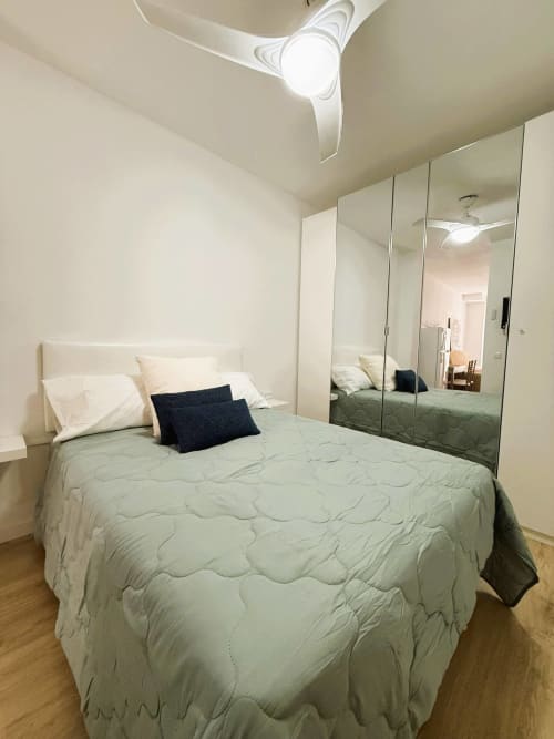 Acogedor dormitorio de estudio frente al mar en Fuengirola con cama de matrimonio, armario espejo y ventilador de techo
