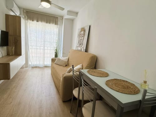 Acogedor estudio frente al mar en Fuengirola con sala de estar, sofá, mesa de comedor y comodidades modernas
