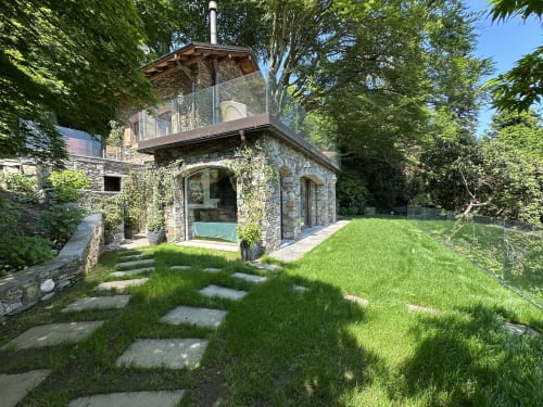Luxury stone villa with terrace overlooking Lake Maggiore, Stresa, featuring lush gardens and modern glass extensions