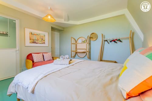 Chambre colorée de la chambre d'hôtes Ô 3 Cyprès de Précy à Neuvy Grandchamp avec lits jumeaux, canapé rouge et vue sur le jardin