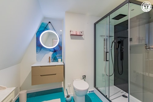 Salle de bain moderne de la Chambre Lantoine à Ô 3 Cyprès de Précy avec sol turquoise, miroir LED circulaire, meuble vasque en bois