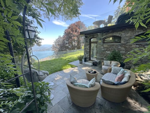 Luxury spa retreat terrace with wicker seating overlooking Lake Maggiore in Stresa, Italy