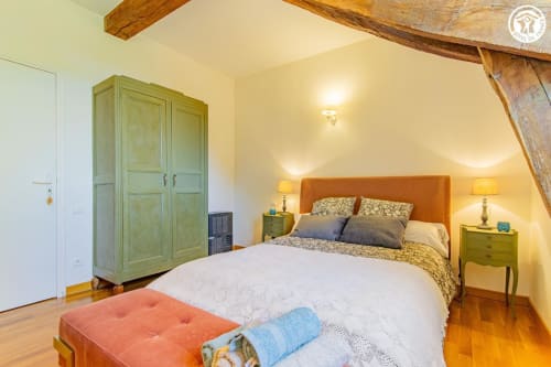 Chambre Charlemagne à Ô 3 Cyprès de Précy à Neuvy Grandchamp avec tête de lit orange, armoire verte et poutres en bois
