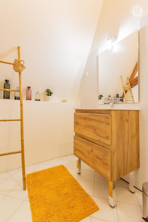 Salle de bain Charlemagne à Ô 3 Cyprès de Précy avec vasque en bois, miroir et accents jaunes