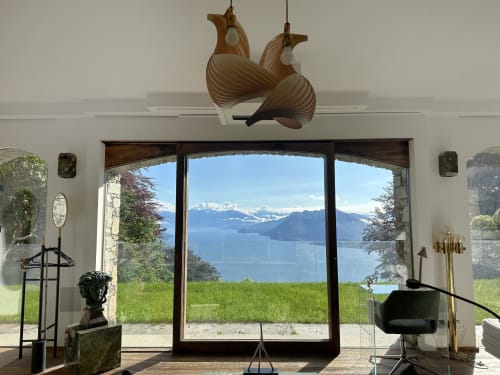 Luxury spa retreat in Stresa with panoramic Lake Maggiore views through floor-to-ceiling windows and artistic wooden ceiling