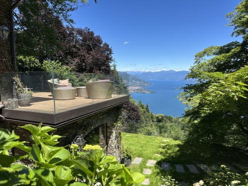 Luxury terrace overlooking Lake Maggiore with modern seating, mountains, and lush gardens at Stresa retreat