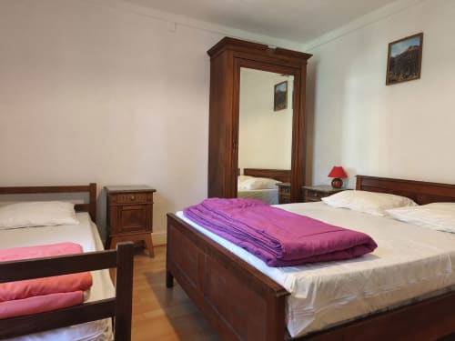 Chambre 3 personnes du Chalet Coste Belle à Ceillac avec lits en bois, couverture violette et vue montagne
