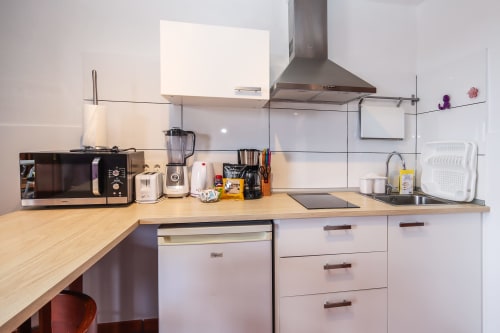 Cocina moderna en apartamento de Villanueva, Lanzarote, con electrodomésticos, encimera e isla con asientos