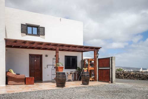 Patio del apartamento Villanueva Lanzarote con pérgola de madera, zona de descanso en terraza y vistas a las montañas en Mala, España