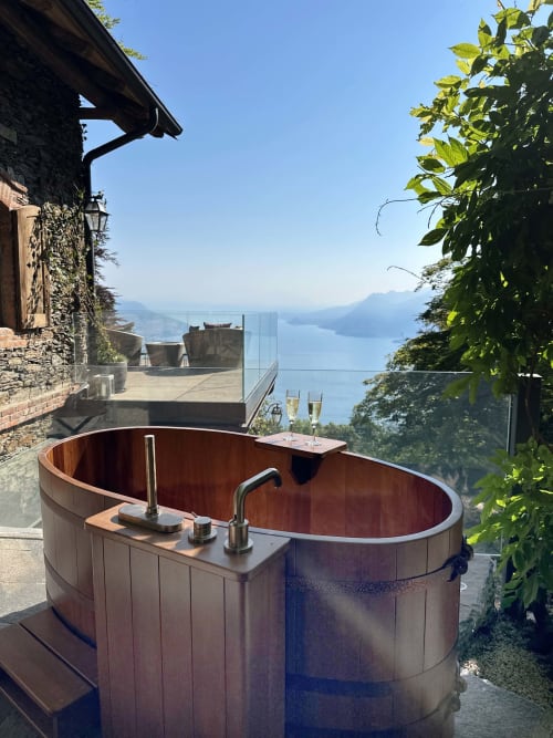 Wooden soaking tub on terrace overlooking Lake Maggiore, luxury spa retreat in Stresa, Italy