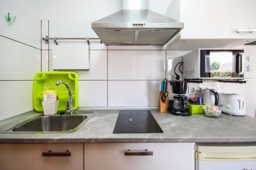 Cocina moderna en apartamento de Villanueva Lanzarote con electrodomésticos de acero inoxidable, encimera gris y placa de inducción