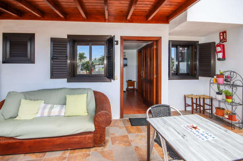 Apartamento en terraza de Villanueva Lanzarote con vista al jardín, amueblado con sofá verde y mesa de madera