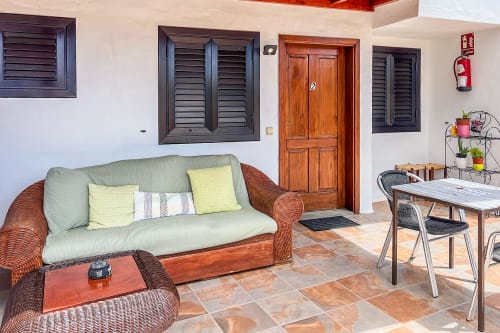 Luminosa terraza de apartamento en Villanueva Lanzarote con cómoda zona de estar, comedor y vistas al jardín en Mala