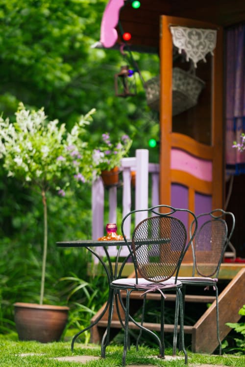 Coin détente du Gîtes du Rouard à Camiers avec chaises métalliques et verdure luxuriante