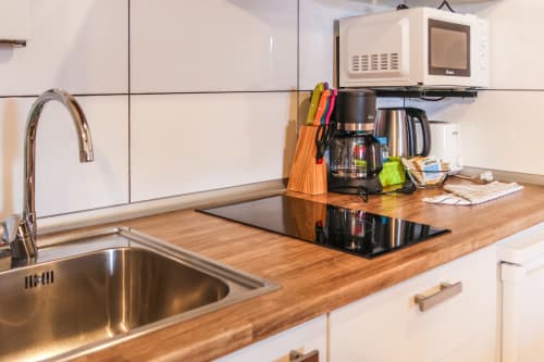 Cocina moderna con encimera de madera, estufa, fregadero y electrodomésticos en el apartamento Villanueva Lanzarote en Mala, España