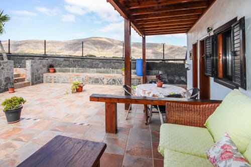 Amplia terraza en Villanueva Lanzarote con vistas a las montañas, mesa de comedor, asientos y comodidades modernas