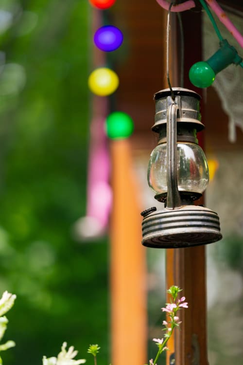 Lanterne vintage avec guirlandes colorées au jardin des Gîtes du Rouard en Camiers, France