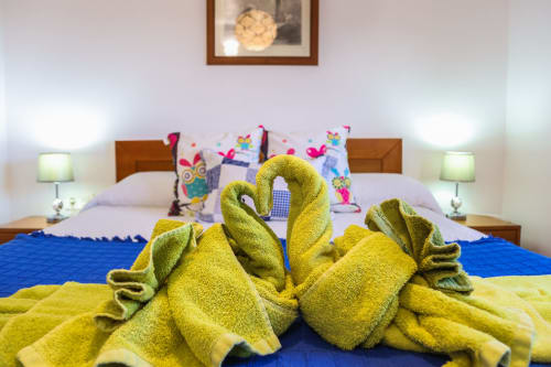 Toalla amarilla con forma de cisne sobre la cama en el apartamento superior Villanueva Lanzarote en Mala, Islas Canarias