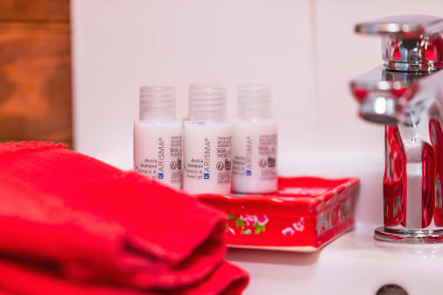 Équipements haut de gamme de la salle de bains du Gîtes du Rouard B&B à Camiers, avec produits Kérastase et serviettes rouges