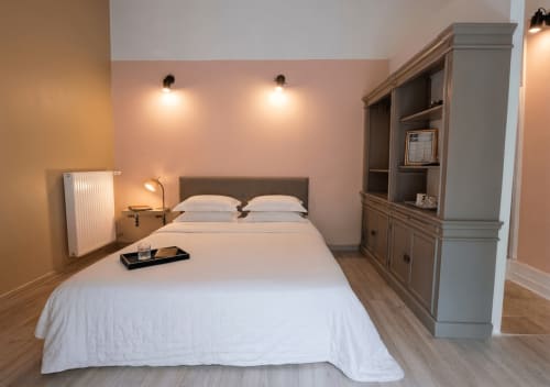 Chambre moderne à La Bastide Des Muriers à Deaux avec lit queen-size, meuble de rangement gris et éclairage ambiant chaleureux