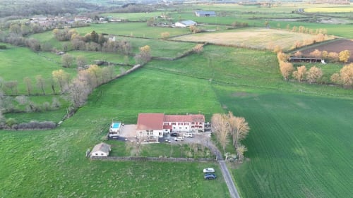 Vue aérienne du gîte Mas De Bannayoux aux toits rouges, entouré de vertes cultures et jardins à Couteuges, France