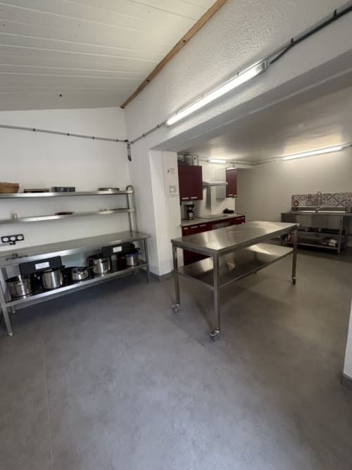 Cuisine professionnelle et salle de réception au Mas De Bannayoux à Couteuges avec tables de préparation et équipements en acier inoxydable