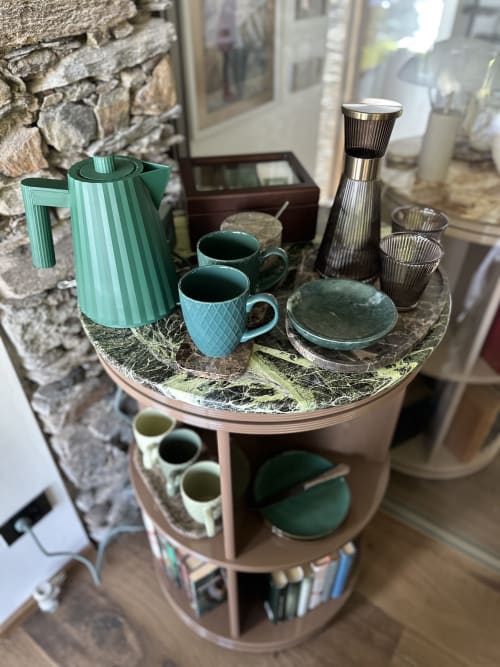 Turquoise kettle and cups with modern glassware displayed on a round table in a luxury spa retreat overlooking Lake Maggiore,