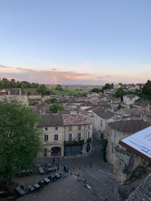 Place du village de Saint-Emilion au crépuscule, bâtiments historiques en pierre et vignobles vallonnés, La Maison du Clocher