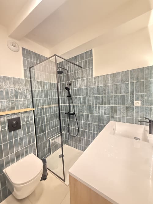 Salle de bain moderne aux murs carrelés gris, douche à l'italienne, toilettes et lavabo blancs de l'appartement Mattbnb à Luxembourg Limpertberg