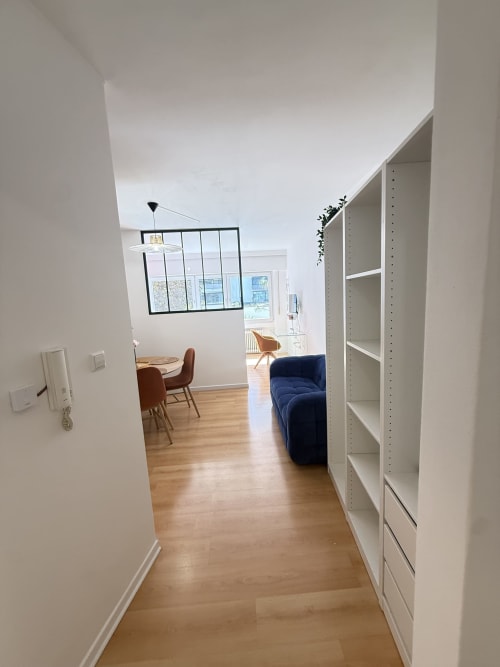 Couloir d'appartement moderne à Mattbnb au Luxembourg avec parquets, étagères blanches et accès à la vue sur la ville