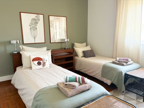 Two twin beds in Room 2 at Casa Idalia Comporta, a B&B in Comporta, Portugal, with cream bedding and green walls