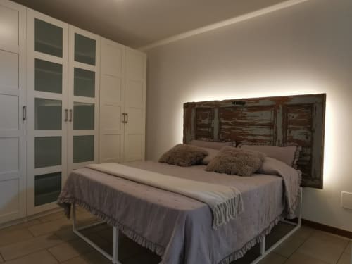 Camera moderna al Kraken Inn Bergamo con testata in legno rustico, armadi integrati e illuminazione d'ambiente