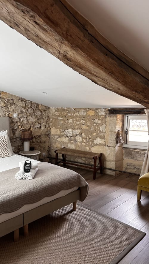 Chambre rustique en pierre avec poutre apparente à La Maison du Clocher, Saint-Emilion