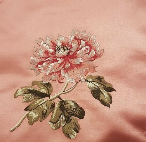 Broderie de pivoine rouge et blanche sur tissu rose à l'hôtel-boutique Camellas Lloret de Montréal