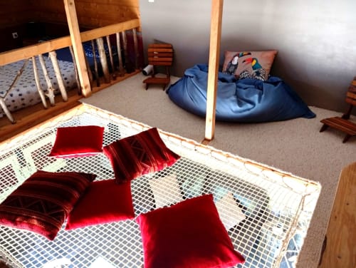 Chambre du gîte Le gîte de Chaparon à Lathuile : lit en bois, coussins rouges, sol chauffant et pouf bleu