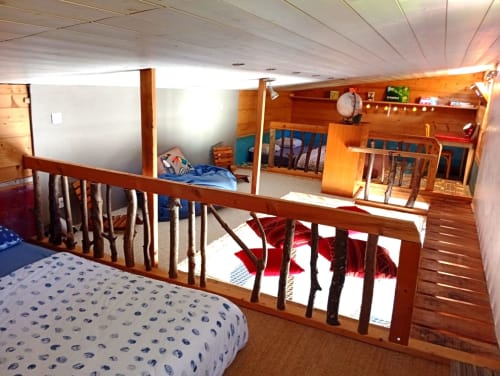 Chambre en mezzanine du gîte de Chaparon, tiny house à Lathuile, avec balustrades bois, lits et vues sur les montagnes