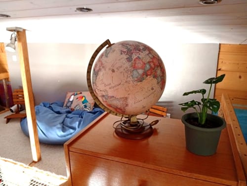Intérieur cosy de la petite maison du gîte de Chaparon avec globe, plante en pot et coin lit