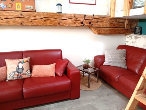Coin salon en cuir rouge avec poutres en bois au gîte de Chaparon, un gîte avec vue montagne à Lathuile, France