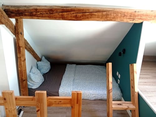 Lit à baldaquin rustique avec mur d'accent bleu-vert au gîte de Chaparon, refuge montagnard de Lathuile