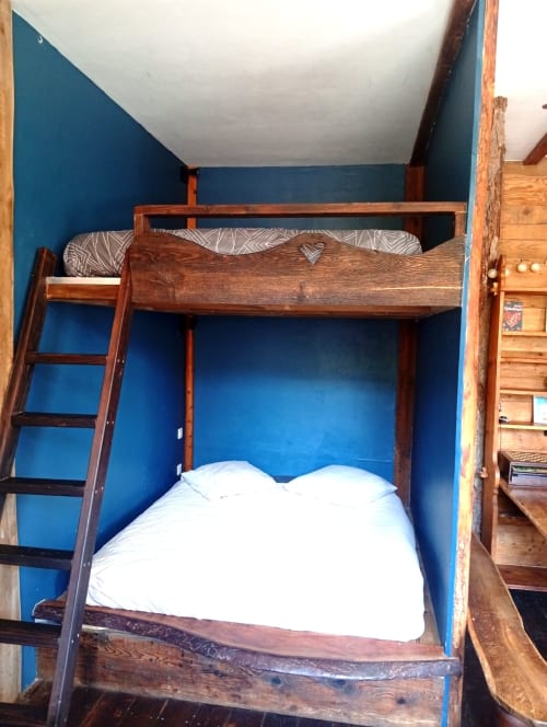 Lits superposés en bois avec literie blanche dans une chambre aux murs bleus du gîte de Chaparon, Lathuile