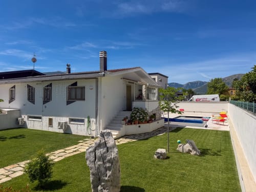 Hotel Stella CasaBono in Sulmona mit weißem Gebäude, gepflegtem Rasen, Pool und Bergblick
